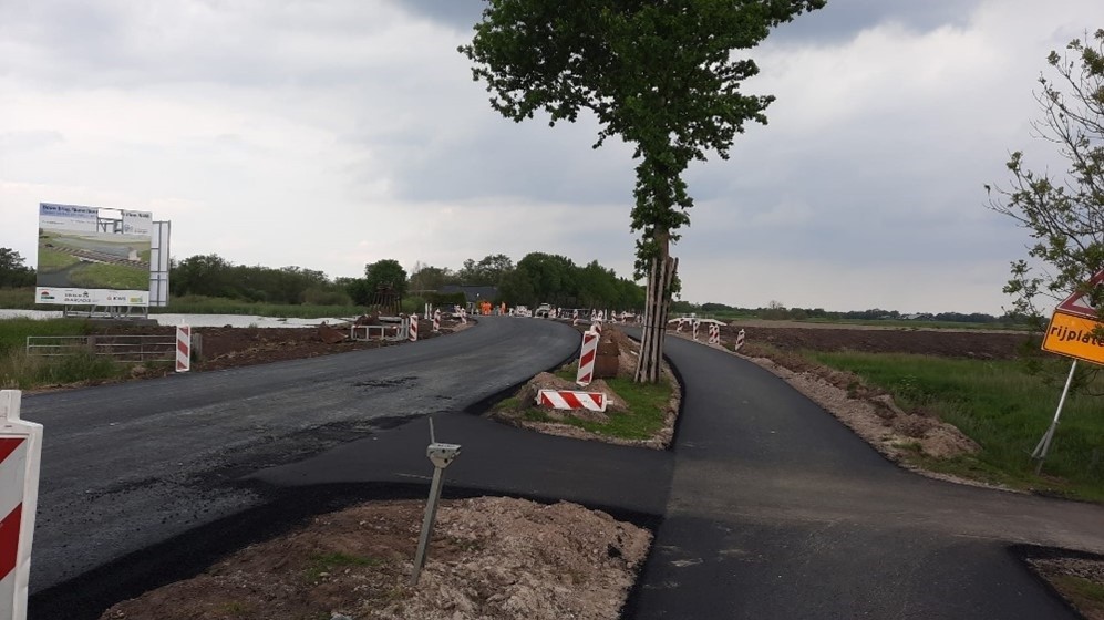 Foto de nieuwe weg en het fietspad met nieuw aangebracht asfalt.
